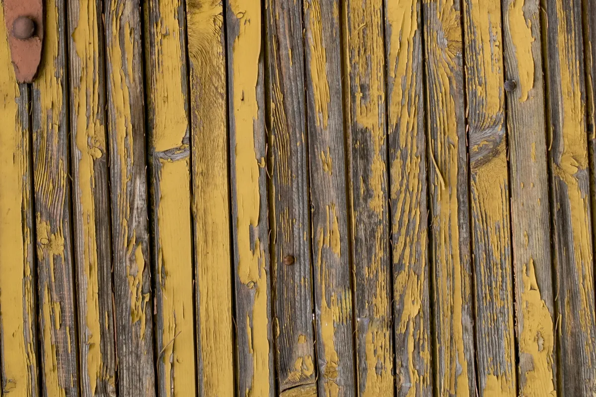 Close-up of weathered yellow painted wooden planks